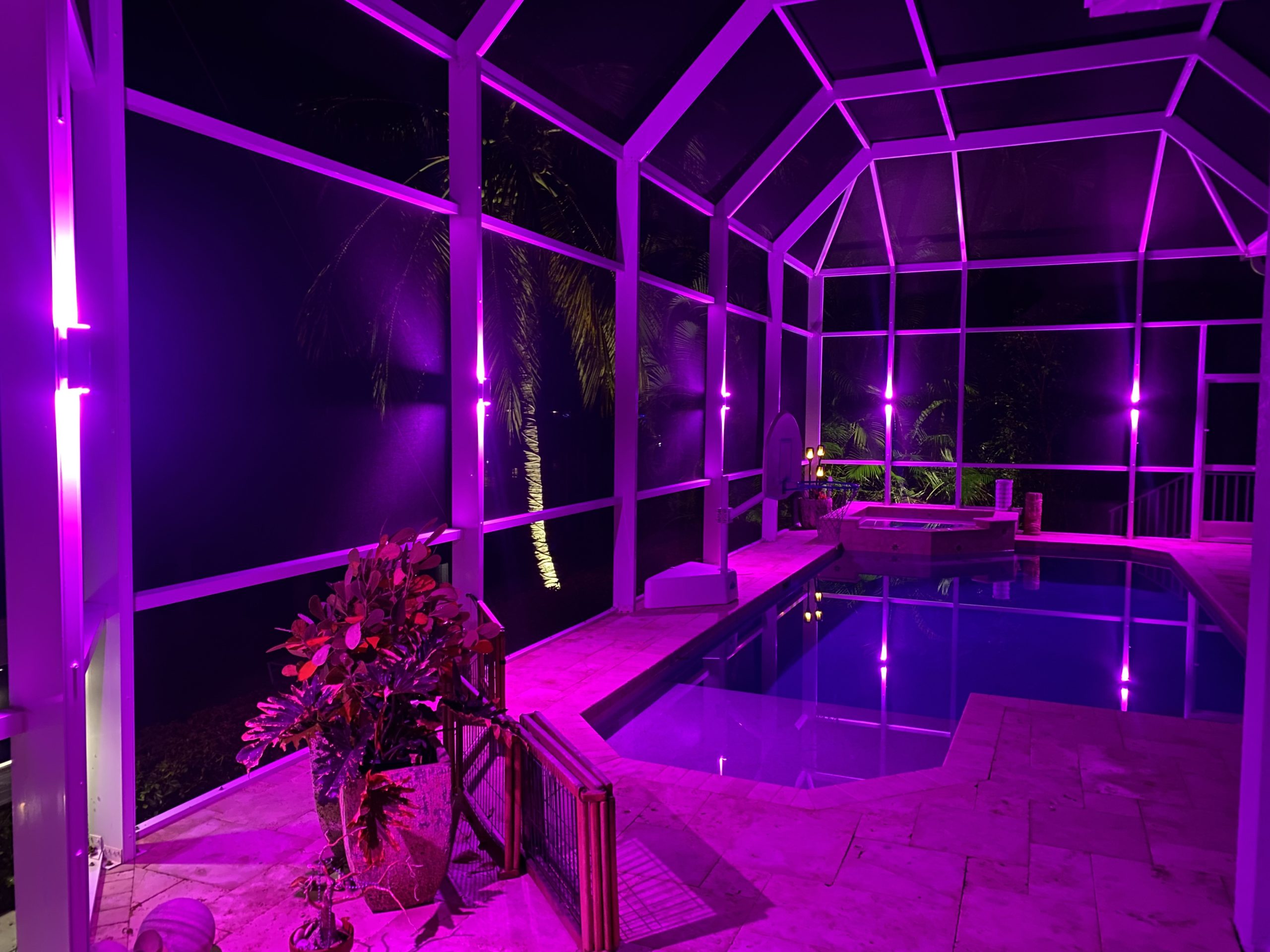 Color changing pool cage lighting project illuminating in pink.