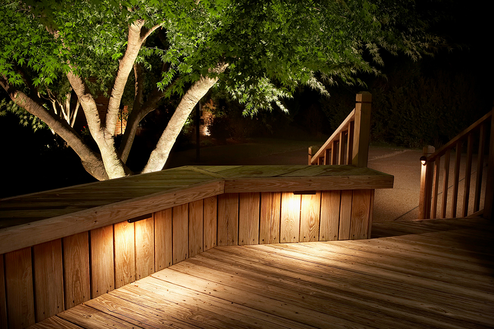 Landscape lighting hardscape lights illuminating wood deck